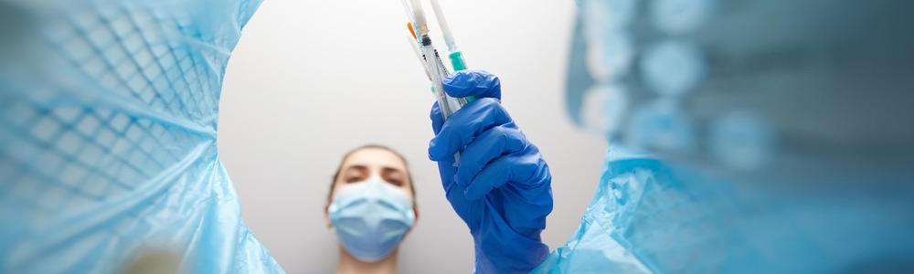 A needle being disposed of in a bin.
