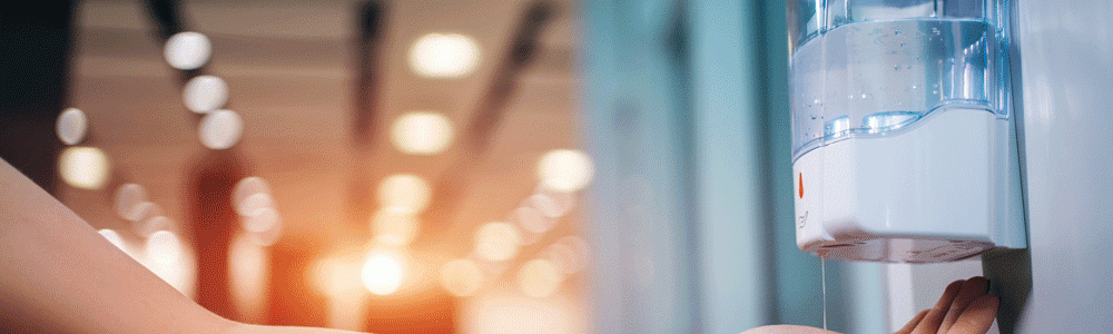 Person getting hand sanitiser from the dispenser.