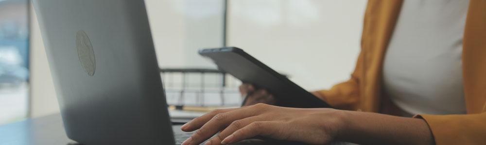 Woman on laptop with phone