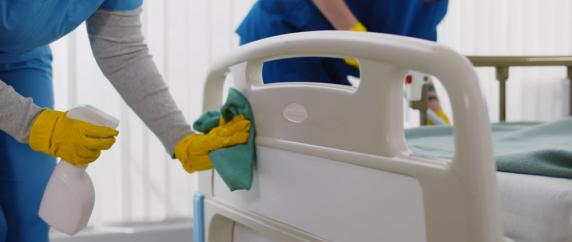 Staff cleaning hospital bed