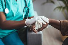 A nurse holds a patient's hand.