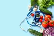 Vegetables surrounding a diabetes tester.
