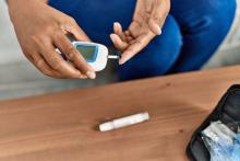 Woman measuring her blood glucose at home.