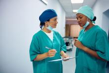 Two surgeons exchange notes.