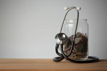Stethoscope and coins in a glass jar.