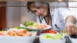 A health worker stocks up for lunch at a hospital canteen. She is eating salad-type food.