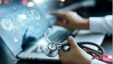 A laptop with data, with hands with a stethoscope