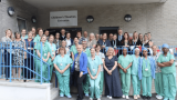 A row of medical staff in blue scrubs standing outside the new surgery unit.