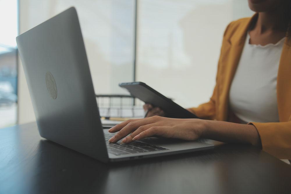 Woman on laptop with phone