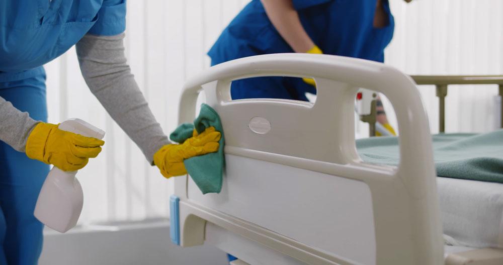 Staff cleaning hospital bed